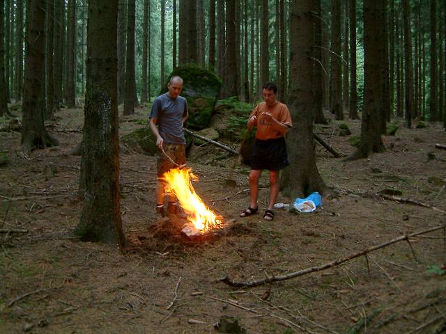 foto č. 025 - Dáda a Eda se nenechávaj odradit šleháním blesků a v klidu si opékaj špekáčky na ohni, který zanedlouho zhasne pod náporem dešťových kapek. Michal šel hledat doklady, protože je hlava děravá a někde v lese je zapomněl.
