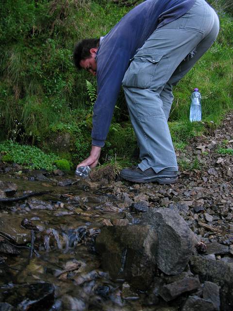 foto č. 079 - Pod loukou nabíráme vodu z potoka, který doslova tryská z nitra svahu.
