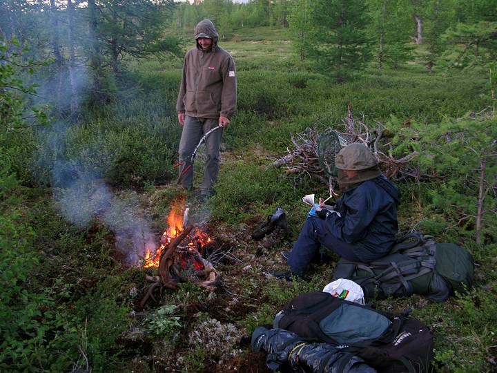 foto č. 107 - Vašek rozdělal oheň a už opéká další porci klobás, zatímco Ilča píše deník.

