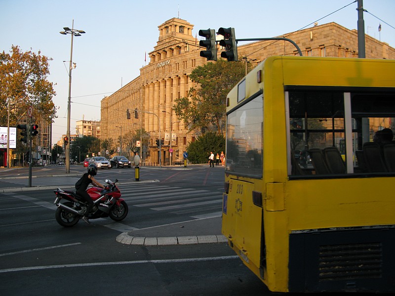 foto č. 092 - Monumentální budova pošty, motorkářka a vomlácenej autobus.
