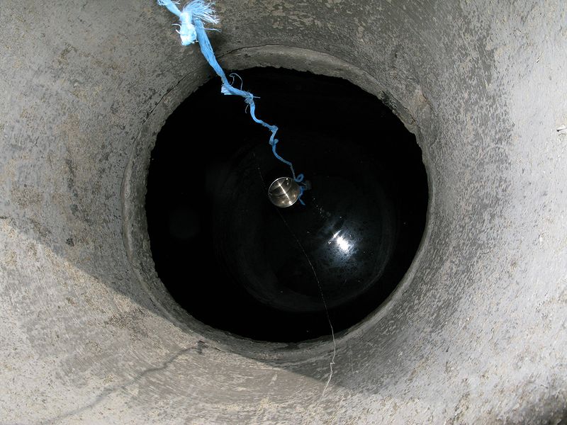 foto č. 035 - Za chatou je studna. Ve skutečnosti je to jen vybetonovaná podzemní nádrž na zachytávání dešťové vody. Voda není křišťálově čistá a je plná chcíplých mušek, ale když je nouze, tak je člověk schopen vypít vše co teče.
